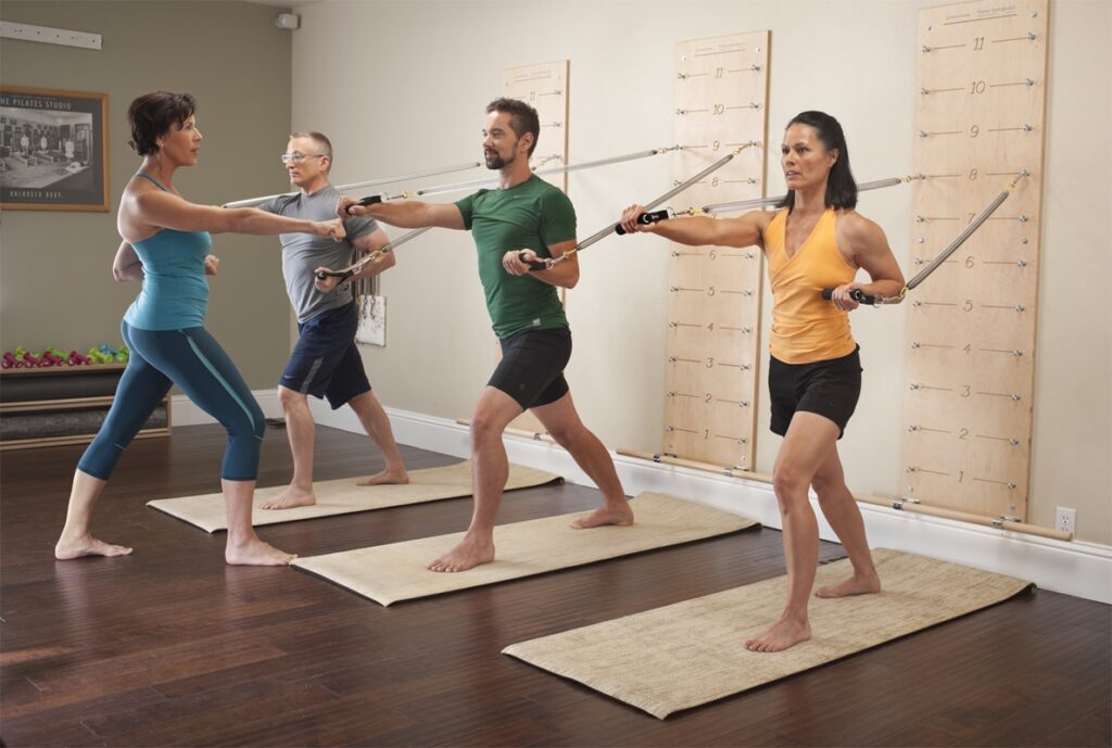 Grupa izmanto Pilates Springboard pilna ķermeņa vingrinājumiem.