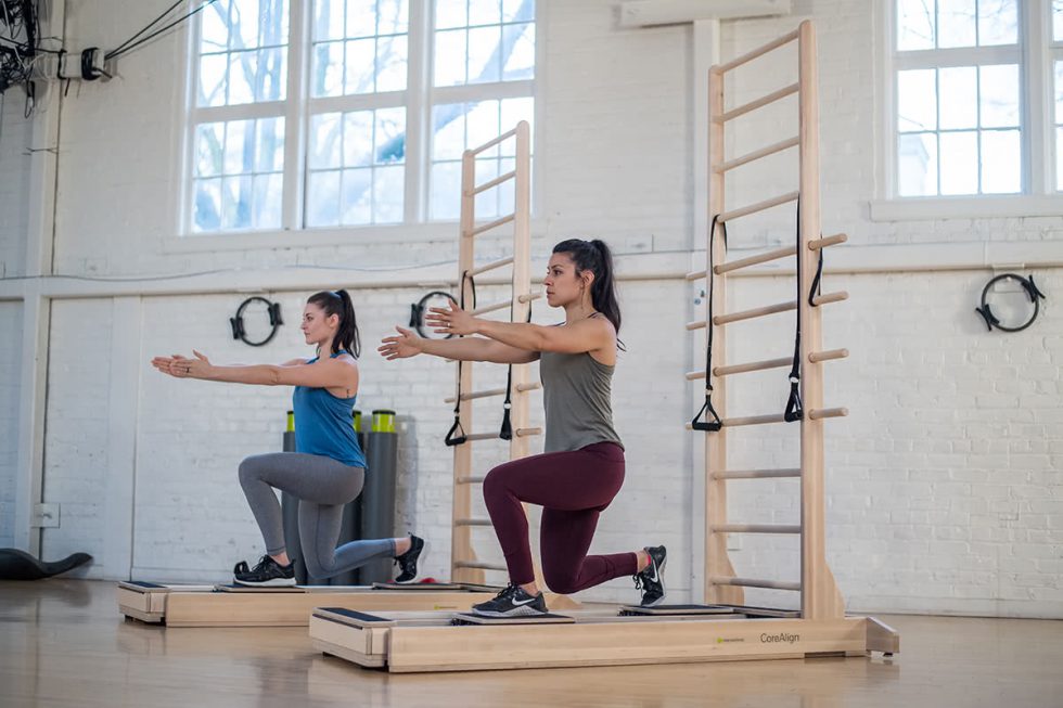 Две женщины занимаются на тренажёре CoreAlign с лестницей в студии.