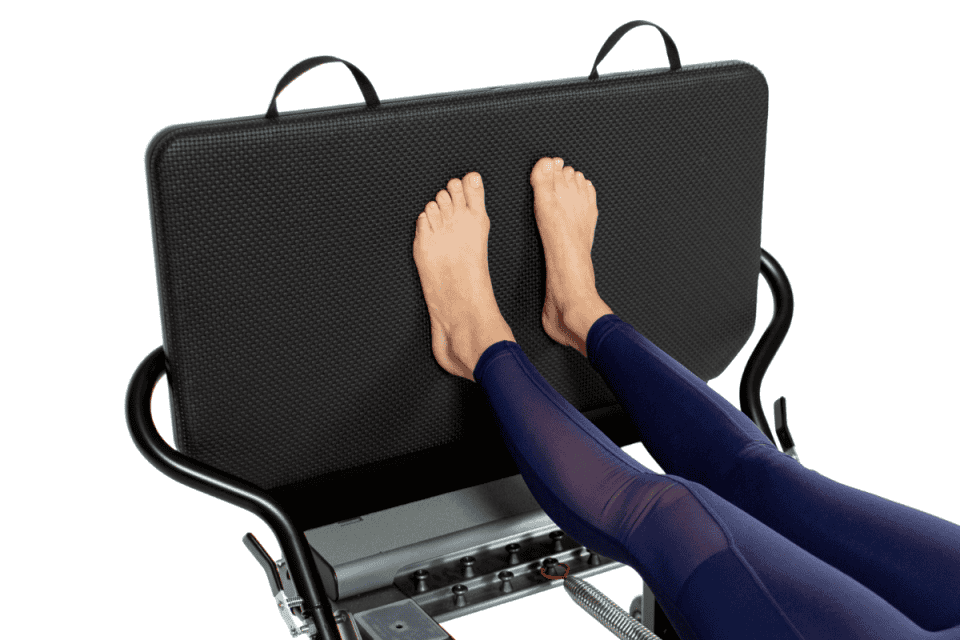 Pēdas uz Allegro Reformer lēcienu dēļa Pilates vingrojuma laikā.