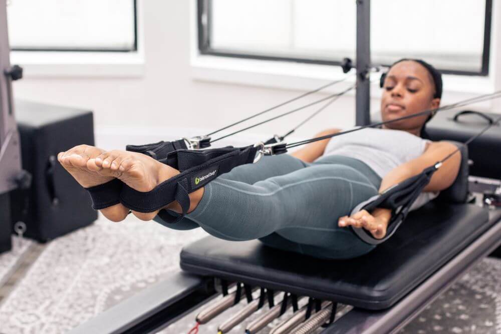 Человек использует Allegro Reformer Konnector для упражнений по пилатесу