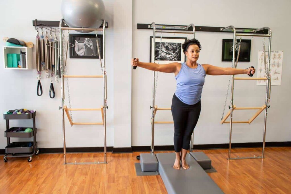 Instructor using CenterLine Pole System for Pilates exercise.