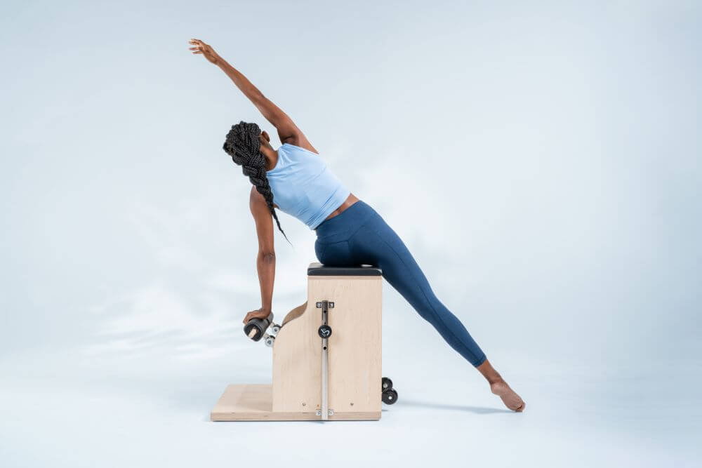 Persona izstiepjas uz Balanced Body Combo Chair Pilates aprīkojuma.