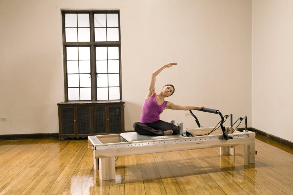 Sieviete praktizē Pilates uz Clinical Reformer studijā.