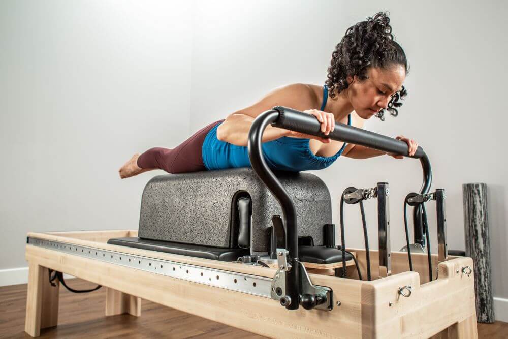 Sieviete vingro uz Balanced Body Clinical Reformer studijā.
