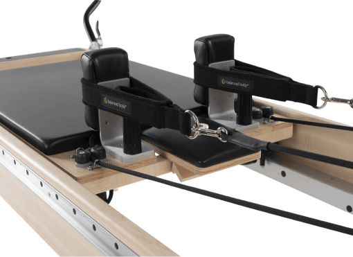 Pilates platforma ar melnu polsterējumu, regulējamu galvas balstu un TwistLock plecu balstiem.