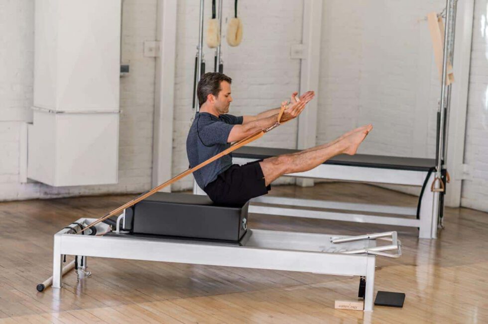 Vīrietis veic vingrinājumu uz Contrology kastes Pilates studijā.