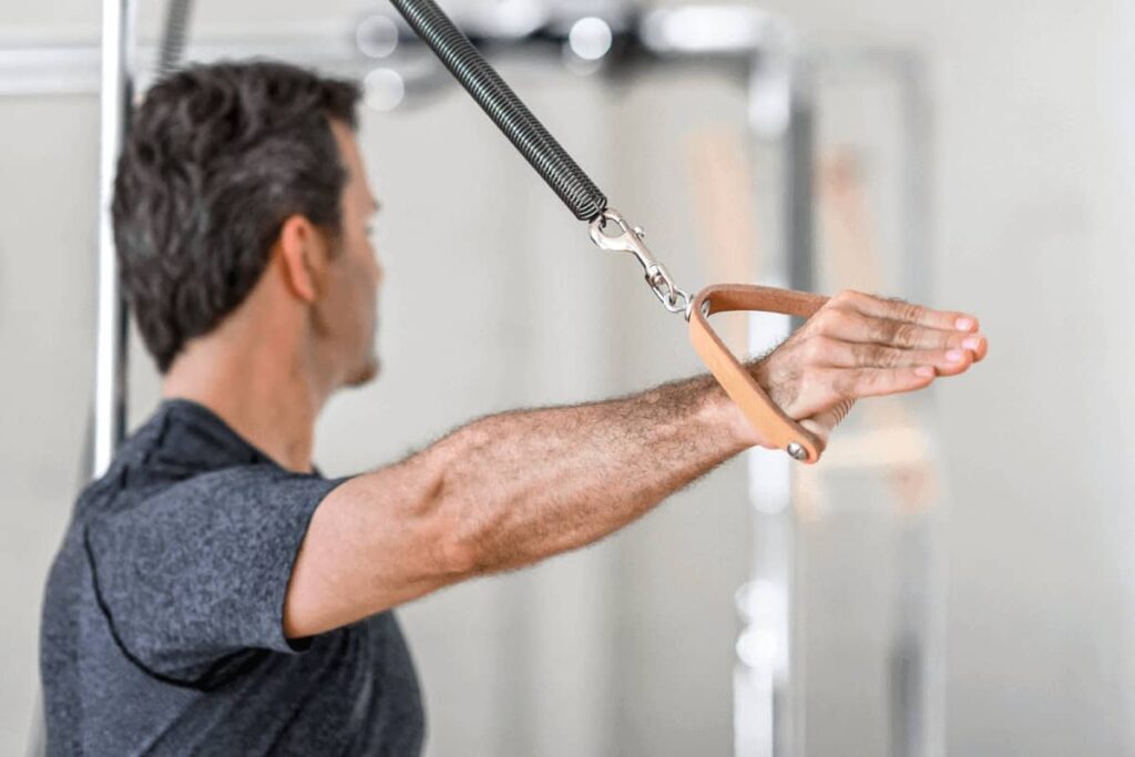 Man using Contrology Contoured Leather Handles for Pilates.
