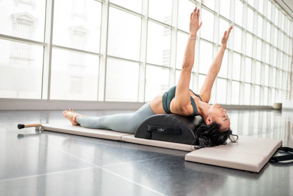 Sieviete vingro ar Contrology Small Barrel Pilates nodarbībā.
