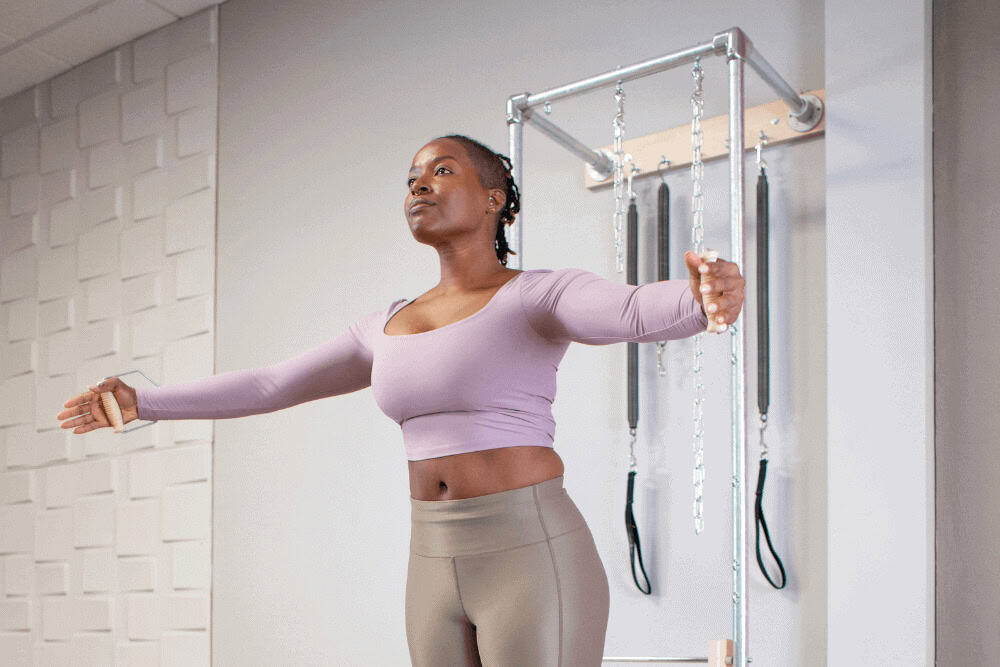 Человек занимается на тренажёре Contrology Wall Tower в студии.