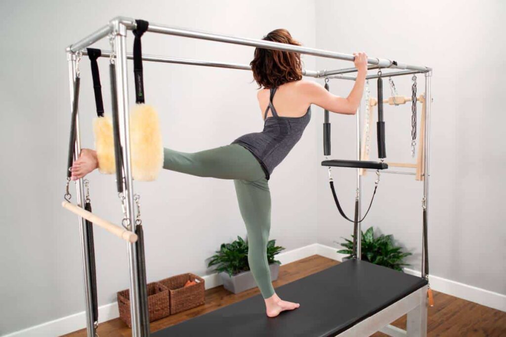 Pilates practitioner using Balanced Body Cotton Web Straps on Cadillac