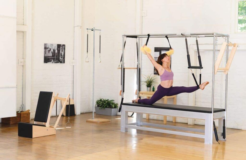 Pilates practitioner using Cotton Web Straps on Cadillac table.
