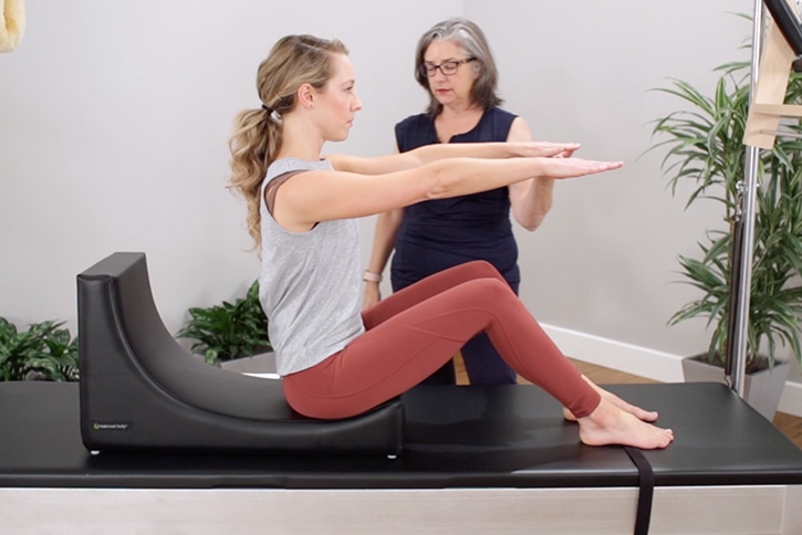 Sieviete izmanto C-Shaper Pilates vingrošanai ar instruktora vadību.