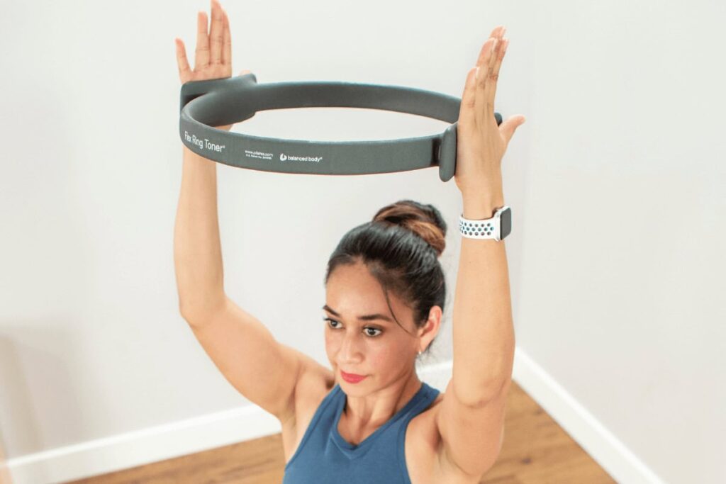 Женщина использует кольцо Flex Ring Toner для упражнения по пилатесу.