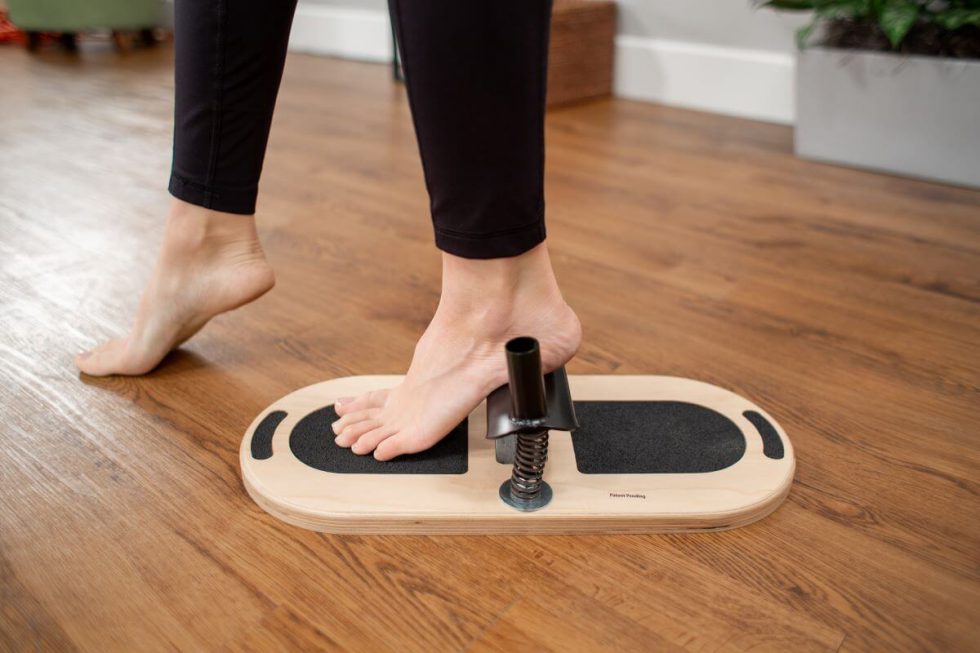 Persona izmanto Balanced Body pēdu korektoru pēdu vingrinājumiem