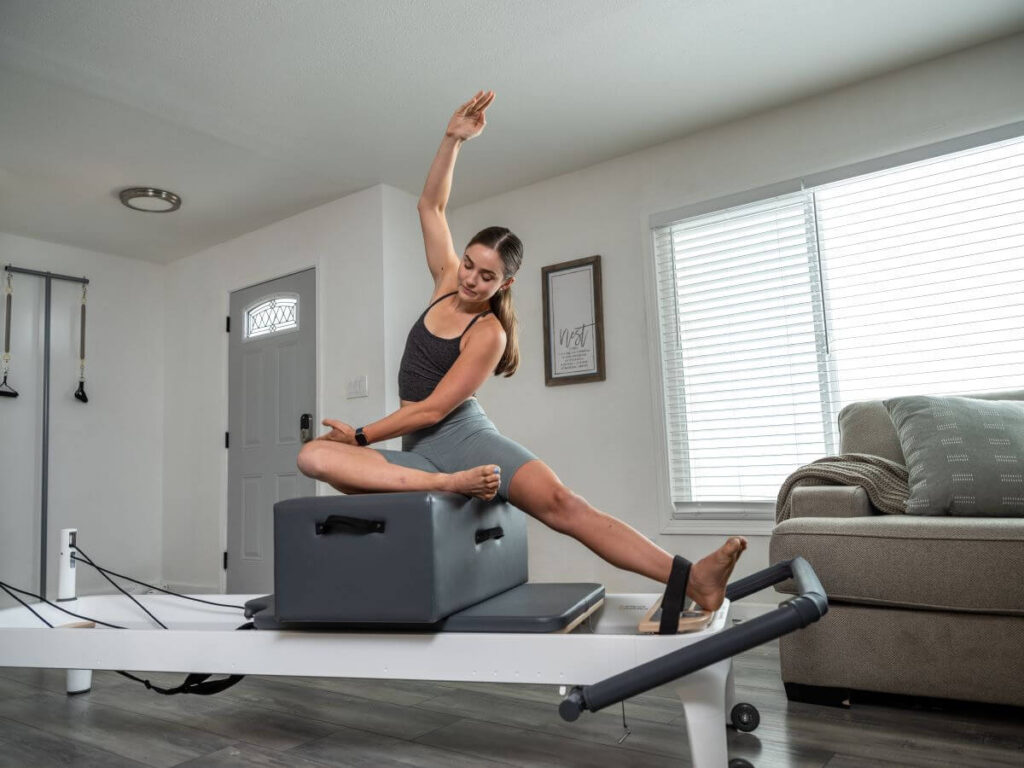 Использование ножного ремешка с сиденьем на реформере для пилатеса.