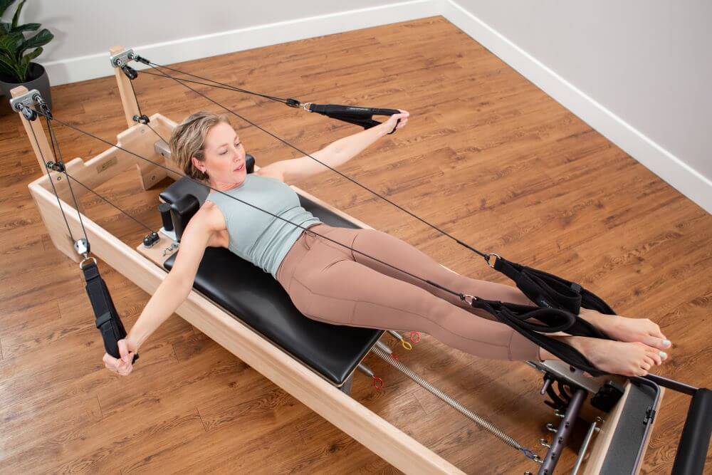 Sieviete vingro uz Studio Reformer Konnector no Balanced Body.