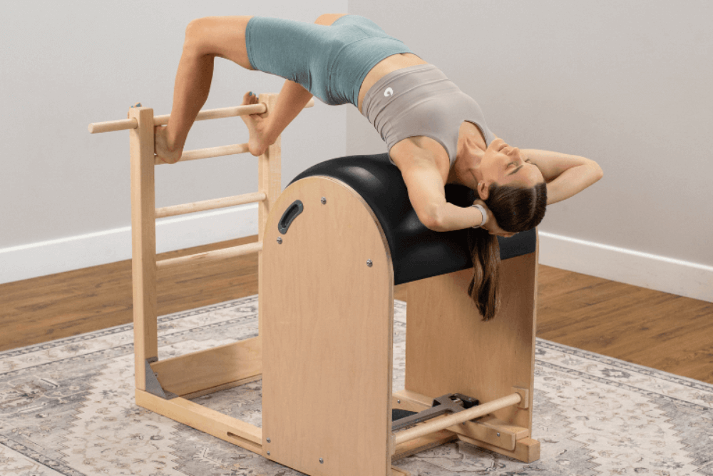 Sieviete vingro uz kāpņu mucas Pilates studijā.