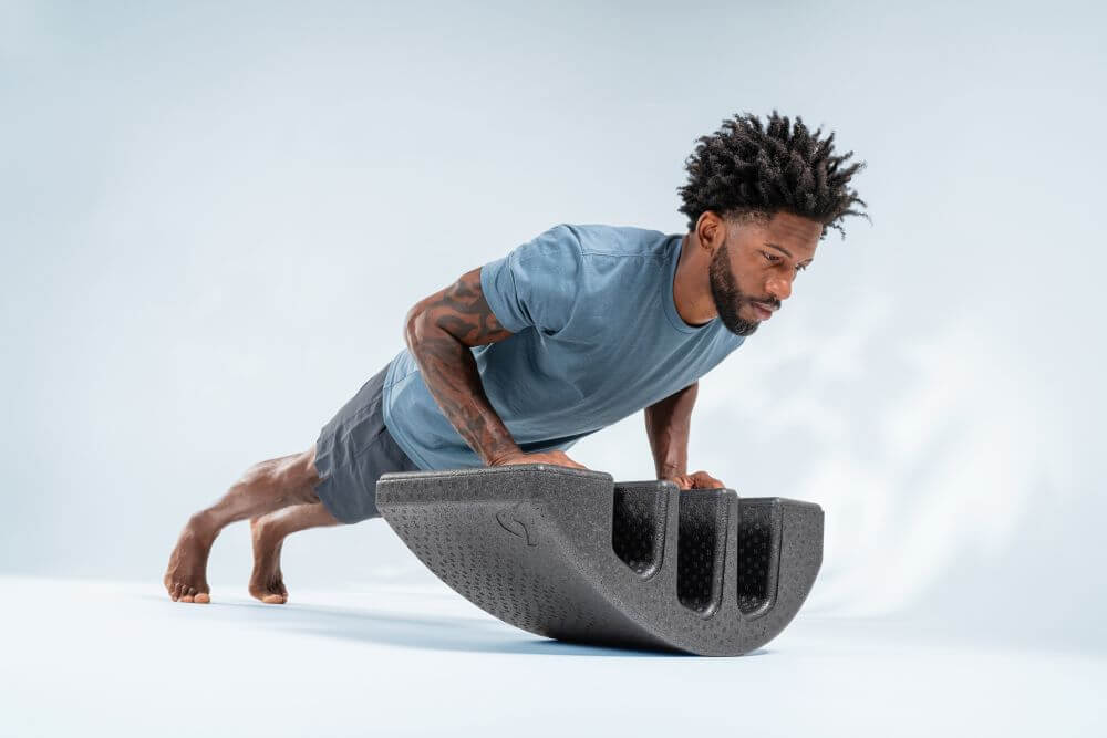 Мужчина выполняет упражнения с дугой Пилатеса для укрепления позвоночника