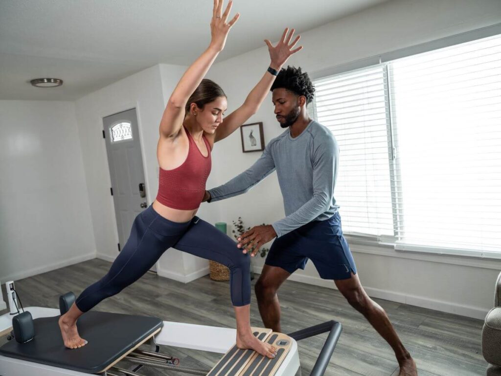 Instruktors asistē sievietei, izmantojot Allegro 2 Standing Platform Extender.