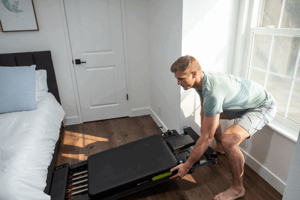 Vīrietis pielāgo Metro IQ Reformer mājas apstākļos.