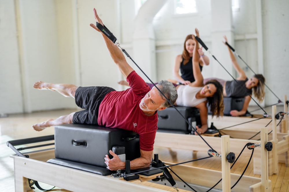 Pilates nodarbība ar New York Sitting Box uz reformeriem studijā.