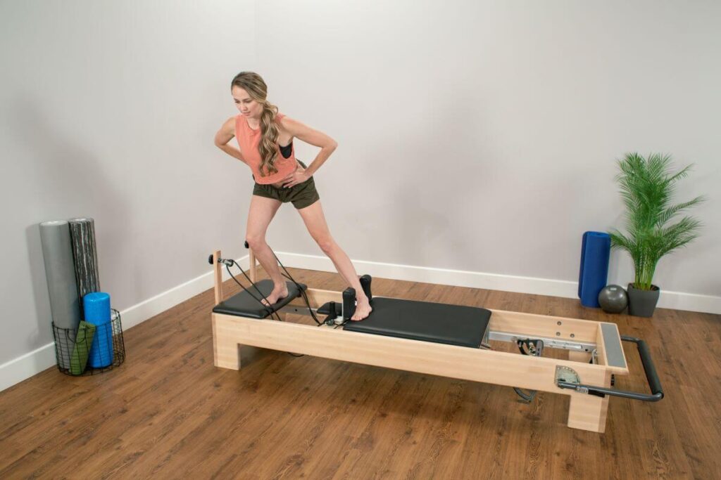 Persona izmanto Balanced Body Studio Add-a-Platform uz Reformer trenažiera.