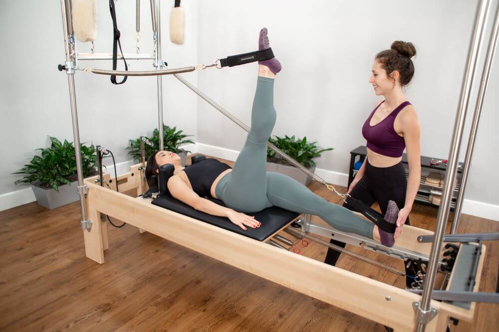 Pilates Reformer un Trapece apvienojums darbībā studijā.