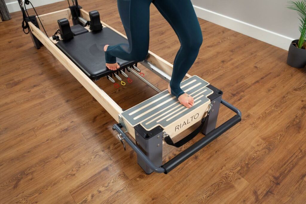 Person using Rialto Standing Platform Extender on Reformer machine.