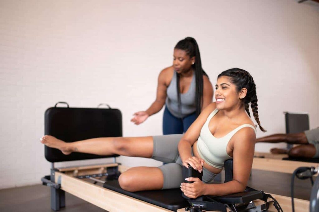 Pilates instruktore vada studentu uz Rialto Reformer Jumpboard