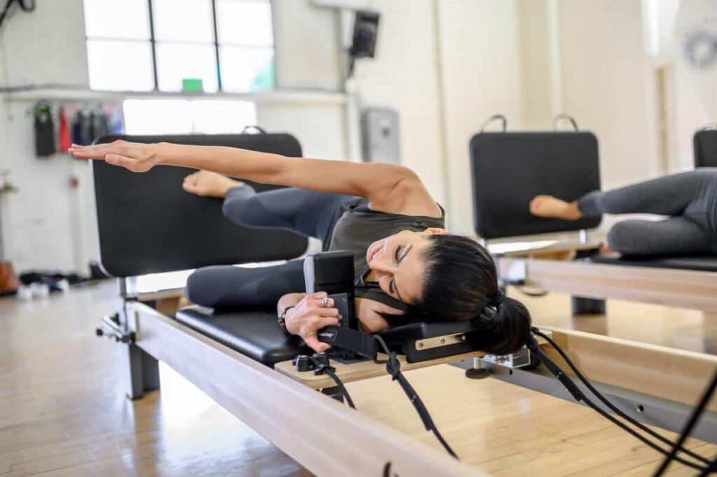 Persona vingro uz Rialto Reformer Jumpboard Pilates studijā.