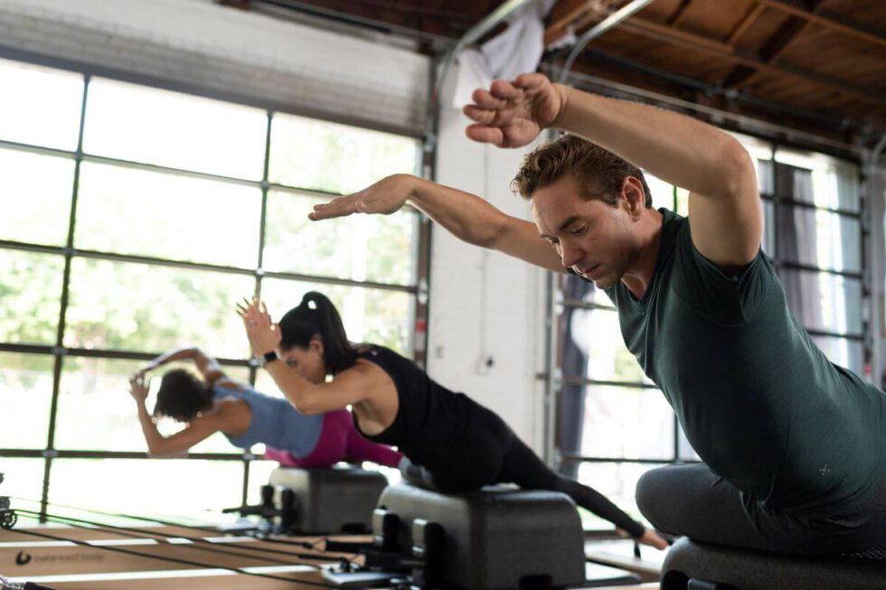Pilates nodarbība ar Sitting Box Lite uz reformeriem studijā.