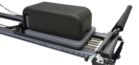 Viegls melns Pilates kaste ar teksturētu virsmu uz reformera.