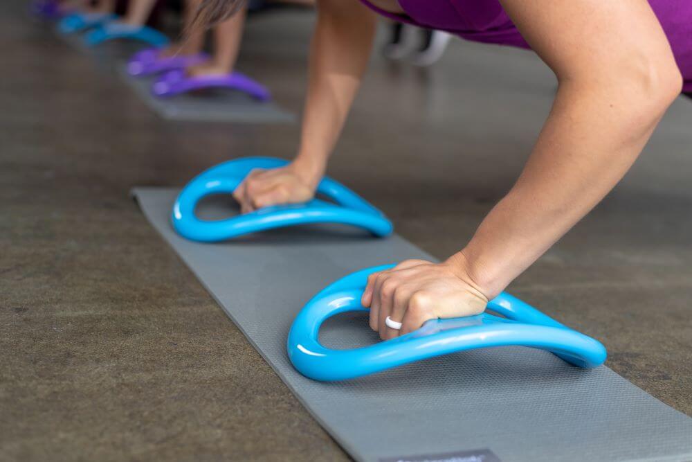 Человек использует SmartBell от Balanced Body для отжиманий.