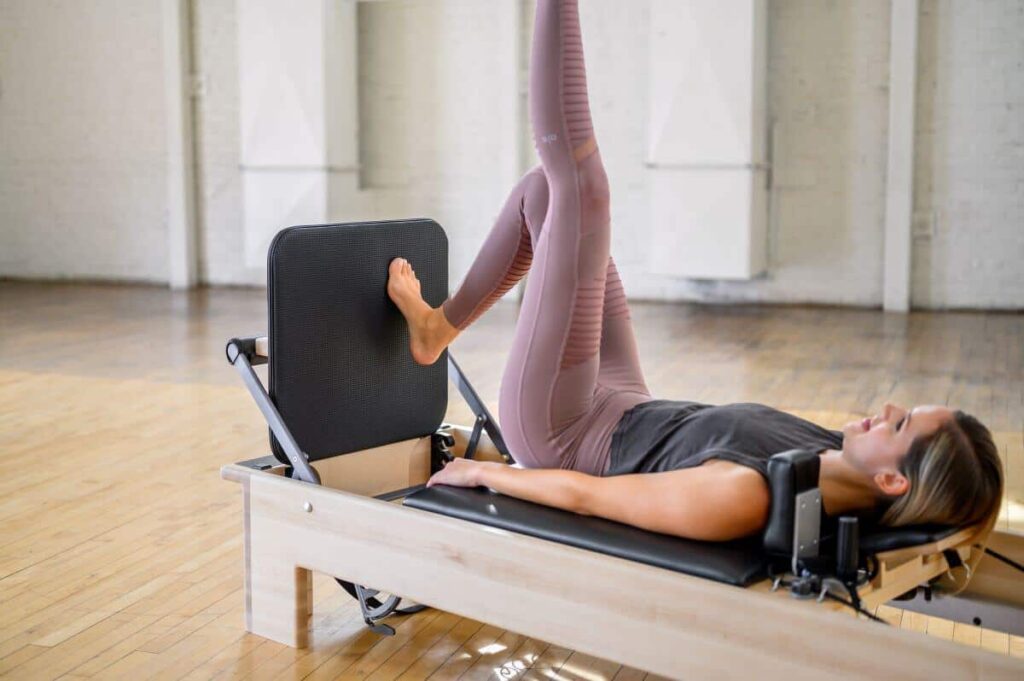 Persona izmanto Studio Reformer Jumpboard Pilates vingrinājumam.