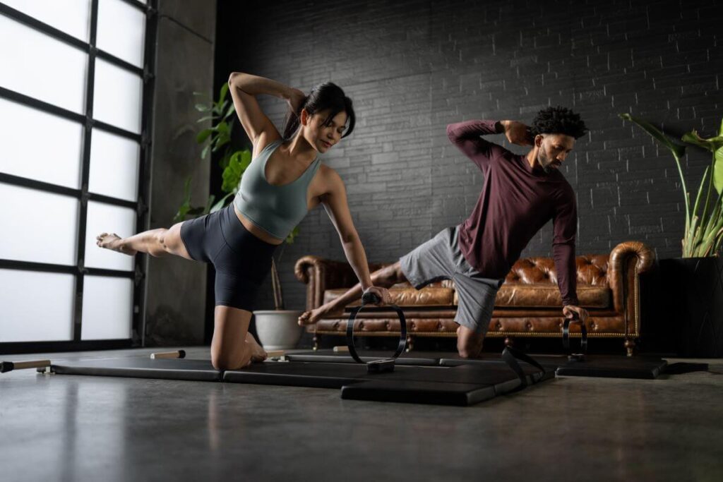 Люди используют пружинный круг Balanced Body для упражнений по пилатесу.