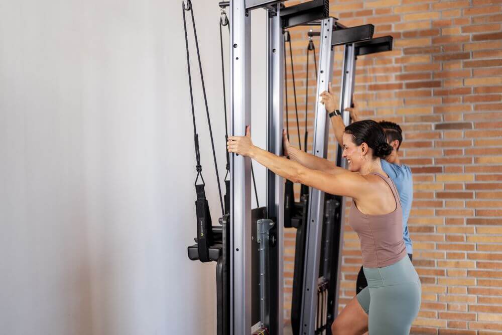 Divi cilvēki izmanto Allegro Nextgen Reformers Pilates studijā.