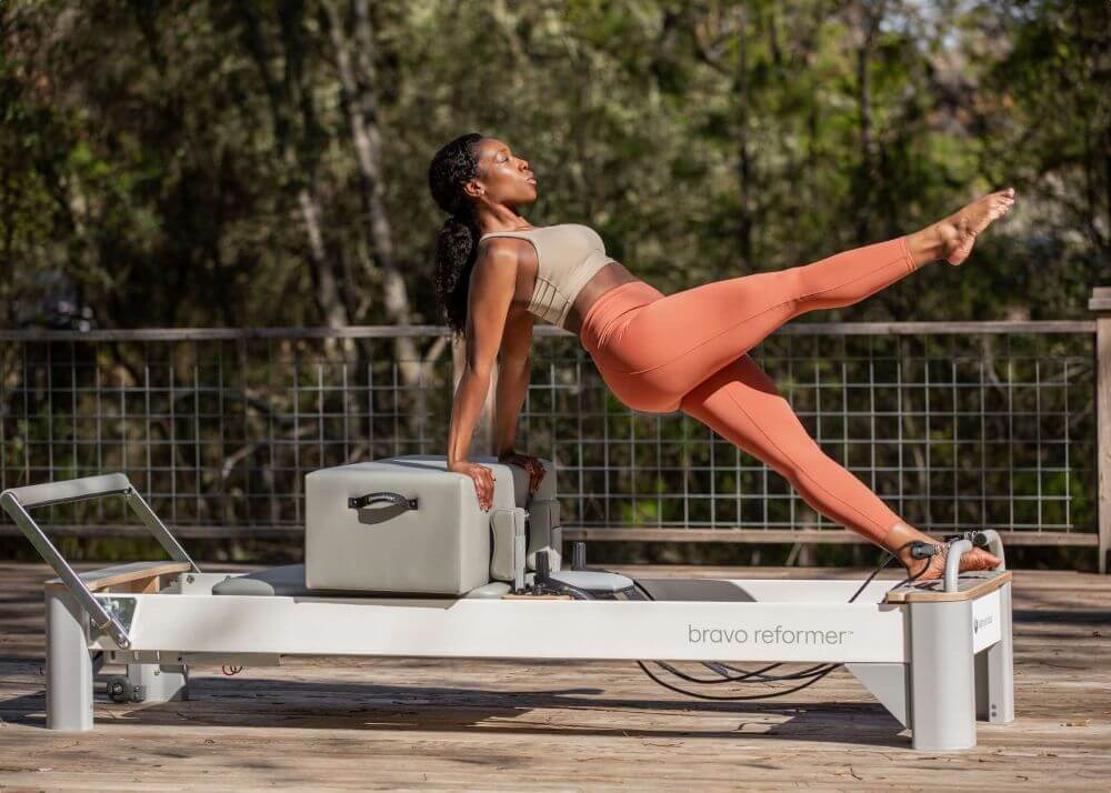 Инструктор по пилатесу использует платформу Bravo Reformer Extended Head End.