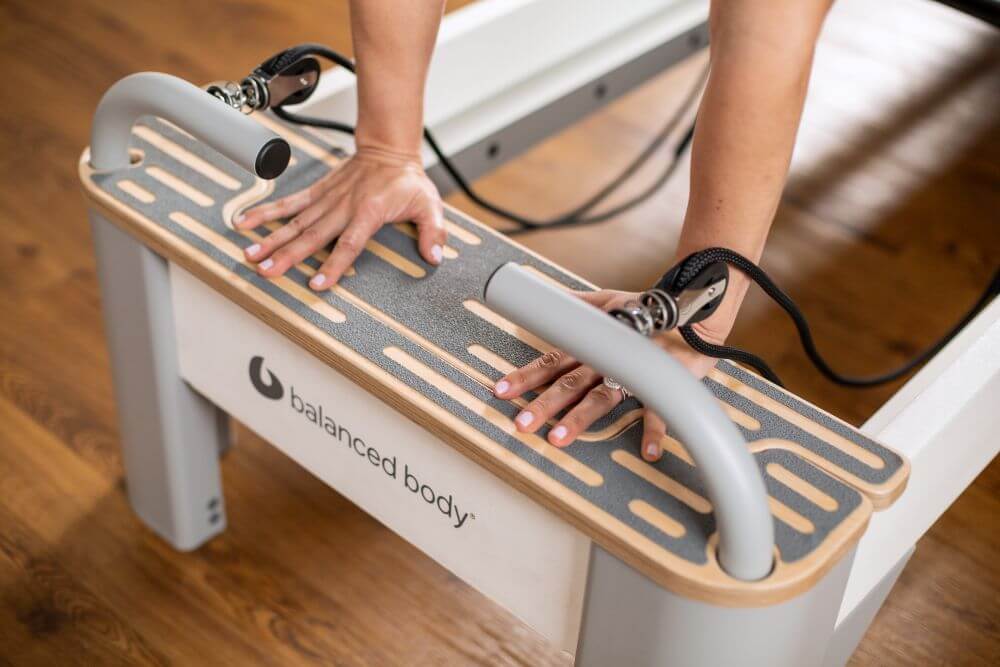 Bravo Reformer Platform Extender ar neslīdošu virsmu un rokām uz platformas.